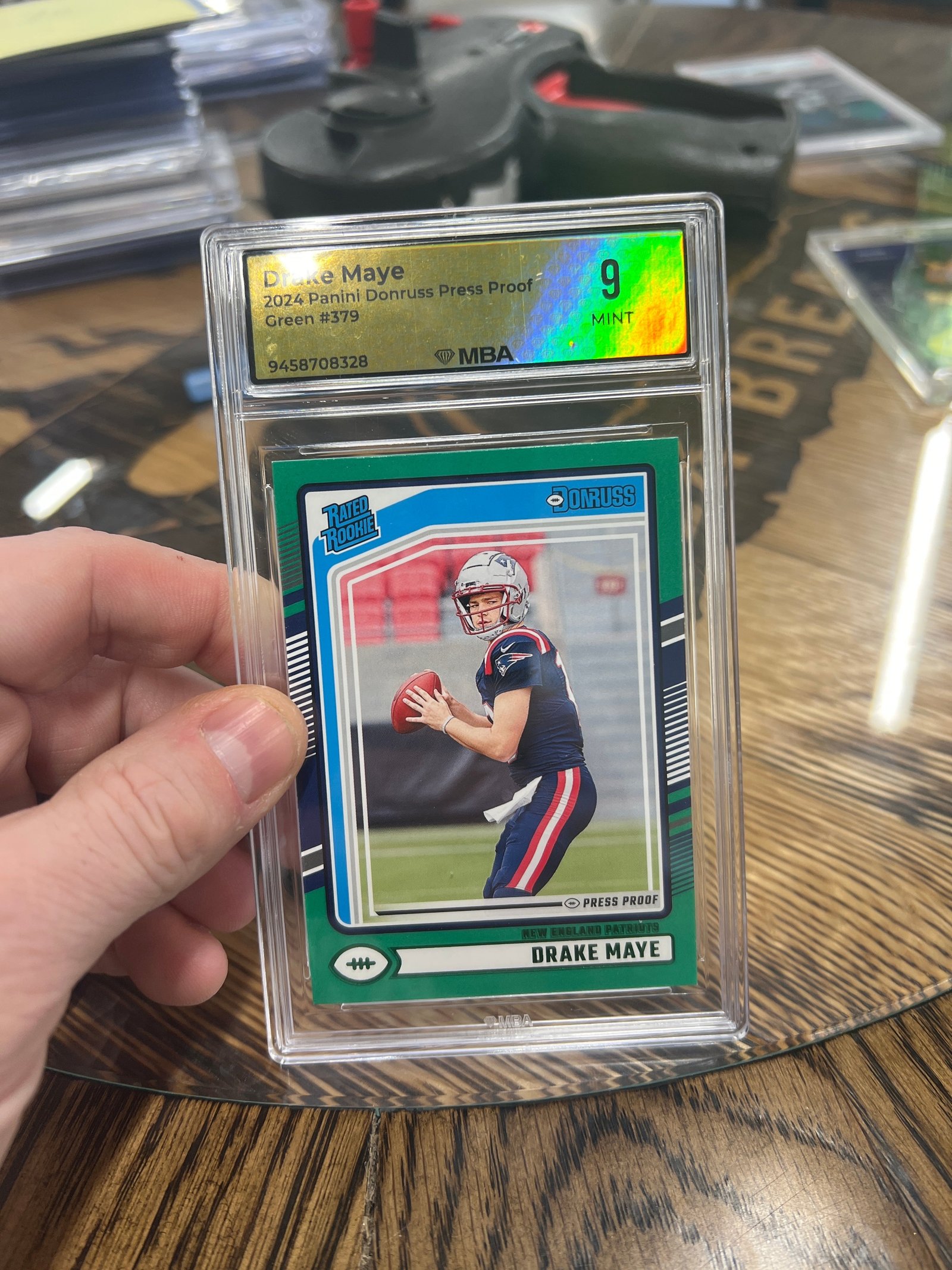 01BB41BD-25E1-4A56-A7C5-463E158505CC Drake Maye 2024 Panini Donruss Rated Rookie #379 Press Proof Green (RC) MBA 9 - Image 1