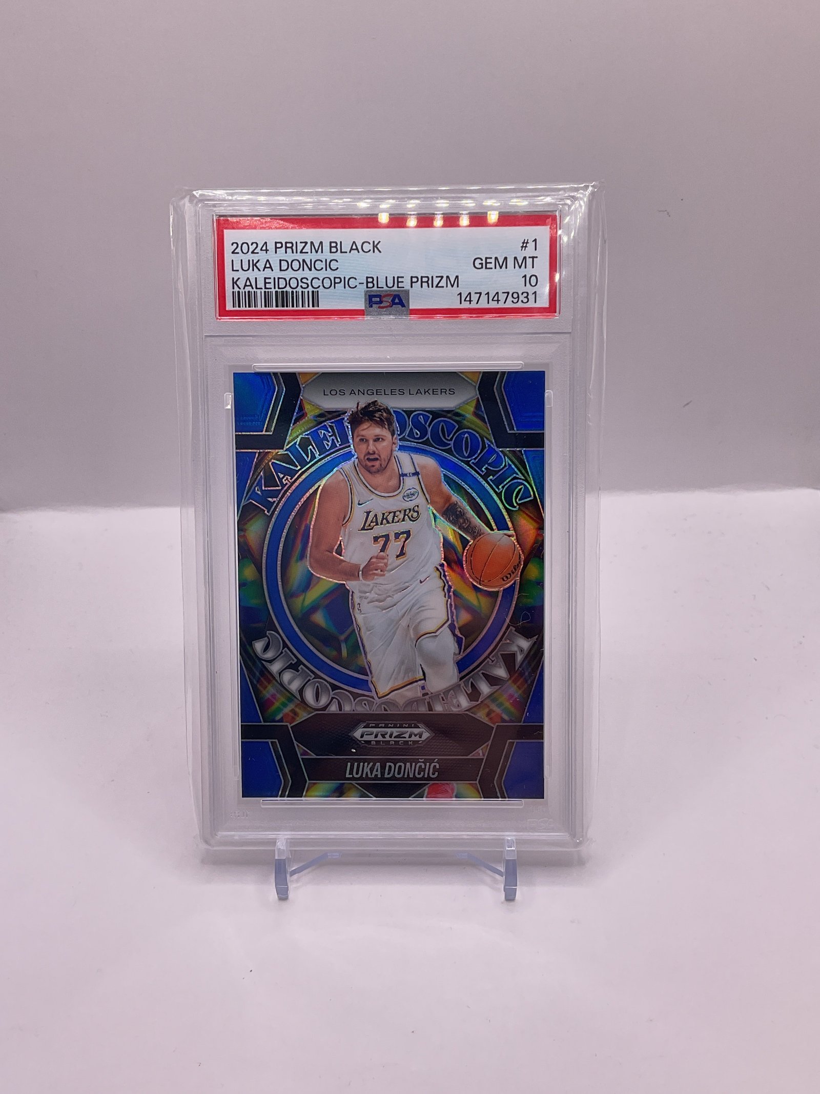 1F701FF4-2990-4E5D-9518-65A9FD7A69A0 2024-2025 Panini Prizm Black Luka Doncic
Kaleidoscopic Blue Prizm /199 #1 PSA 10 - Image 1